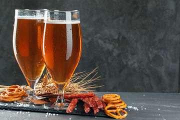  beer and appetizing beer snacks set. Table with mug of beer, wooden board with sausages