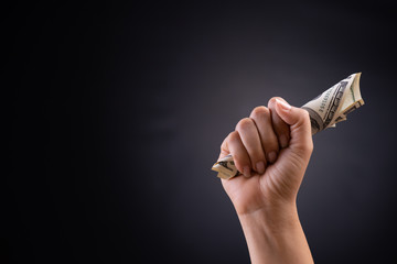 Wall Mural - Close up woman hand holding American dollar in the dark background. Business finances, savings and bankruptcy concept.