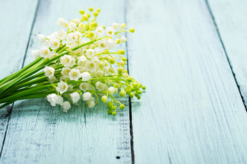 bunch of lily of the valley flowers on faded blue table