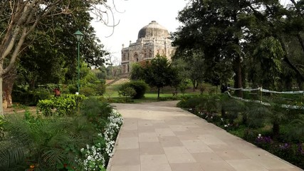 Wall Mural - gimbal shot walking along a path at lodhi garden with shish gumbad tomb in the distance, new delhi