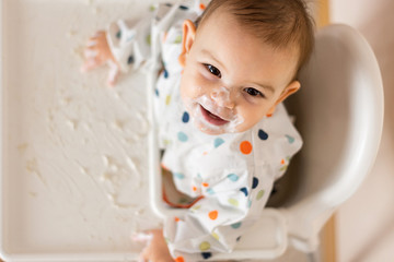 a little baby eating her dinner and making a mess