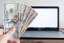 Dollar Banknote On A Laptop. Earned Money By Working From Laptop At Home.Freelance Work Making Money Concept