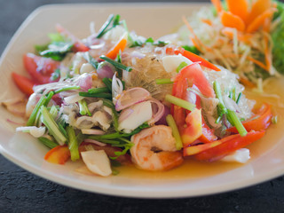 Wall Mural - Traditional Thai cuisine. Rice noodle salad, fresh vegetables and herbs and seafood on a plate in a cafe. Authentic fresh traditional thai food at the restaurant