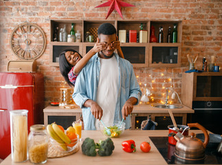 Wall Mural - Black couple having fun while cooking on kitchen