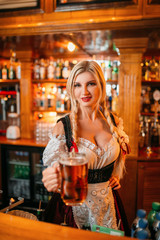 Sexy waitress held out a mug of fresh foamy beer