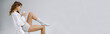 © LIGHTFIELD STUDIOS - panoramic shot of beautiful woman sitting on chair and holding cup on grey