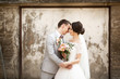 © Olha - beautiful wedding couple kissing near the old wall