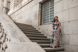 Fototapeta Na drzwi - beautiful asian Philippine female in her 20s posing against a stone wall on stairs  showing her sexy face and soft skin with her elegant dress looking to her right off into the distance 