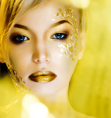 beauty blond woman with gold creative make up