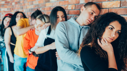 Tired of waiting. Millennials queue. Men women standing in line leaning against brick wall. Moving forward with patience.