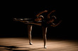 © nagaets - Flexible ballerinas stretch on a dark lighted scene