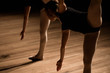 © nagaets - Flexible ballerinas stretch on a dark lighted scene