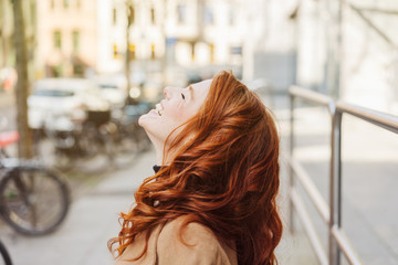 Wall Mural - Laughing young woman enjoying the spring sun