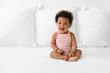 © Lisa Tichané - Happy black baby sitting on bed