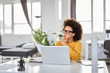 © nenadaksic - Serious mixed race attractive businesswoman dressed smart casual holding paperwork while sitting in modern office.