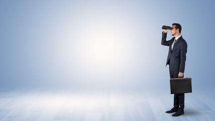 Wall Mural - businessman looking forward with binoculars in an empty space