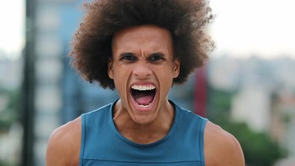 angry african man screaming from the top of his lungs looking to camera