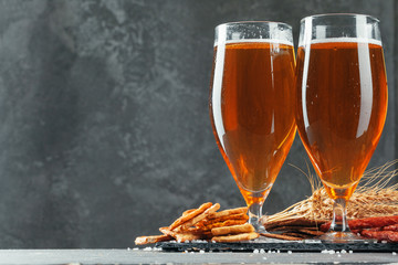 Beer glass with bretzel and dried sausages snacks close up