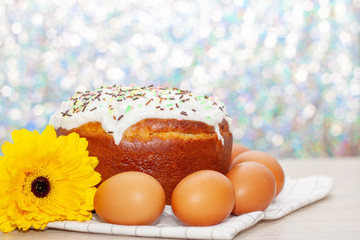 Easter cake and colored eggs yellow flower blossoms on background. Holiday food and easter concept. Selective focus. Copyspase