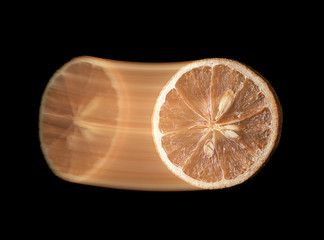 Citrus fruit swinging on black background