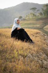 Canvas Print - beautiful woman with hijab sitting outdoor enjoy nature in the morning