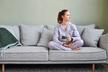 Pretty Pajamas Girl On Sofa With Morning Coffee