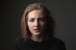© Dima Aslanian - Puzzled young woman on the black background