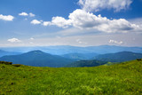 Fototapeta Morze - Green mountains panorama under blue sky on bright sunny day. Tourism and traveling concept, copy space background.