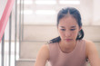© TeTe Song - Unhappy depressed teenager with face in hands sitting stair at old condo , Sad girl, Cry, drama concept