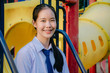 © TeTe Song - Portrait of asian girl student in school uniform Thailand style, sitting on swing and enjoy herself in windy and sunny day.