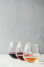 Variety Of Wine. Red, Rose And White Wine In Old Fashion Glasses In Row On White Marble Table. Copy Space