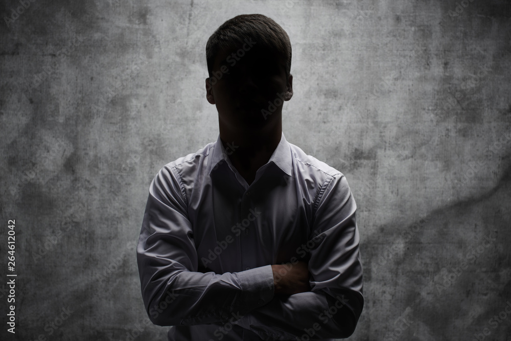 Anonymous man in a business shirt with arms crossed against a dark background - obrazy, fototapety, plakaty 