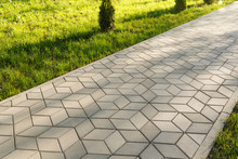 The Footpath In The Park Is Paved With Diamond Shaped Concrete Tiles.