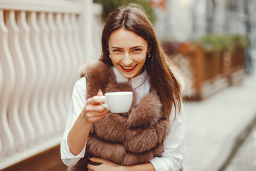 The girl on the street. Woman and coffee. Beautiful girl resting