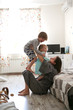 © natalialeb - Happy mother hugs her children siblings on floor
