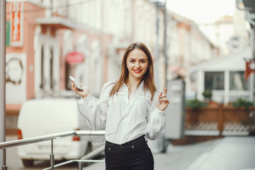 The girl walks around the city. Girl with phone. The girl is outdoors