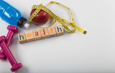 Weights, water, apple, and tape measure on a white background. healthy lifestyle