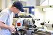 © industrieblick - technsiche Berufsausbildung - junger auszubildender an der Drehbank einer C_NC Maschine // young apprentice in vocational training working on a turning machine in the industry