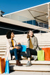 © Westend61 - Two happy women with shopping bags sitting on stairs