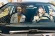 © Westend61 - Two women driving in a car through the city
