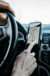 © Westend61 - Close-up of woman driving in a car using a telephone navigation app