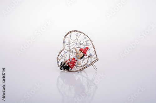 Pinocchio doll sitting in a heart shaped cage