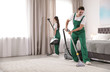 © New Africa - Team of janitors cleaning bedroom with professional equipment