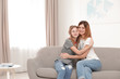 © New Africa - Happy mother hugging her teenager daughter at home
