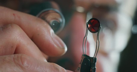 Wall Mural - Slow motion macro close up of experienced goldsmith controlling a quality of rubin stone, selected for making jewels in workshop.Shot in 8K. Concept of jewelry,luxury,goldsmith, diamonds, brilliance.