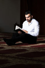 Wall Mural - Muslim Man Reading Holy Islamic Book Koran