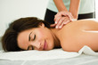 © javiindy - Young woman receiving a back massage in a spa center.