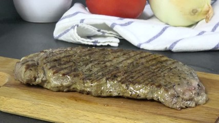 Wall Mural - Placing a grilled rib steak on a cutting board to slice