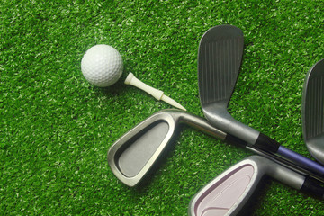 Golf balls and golf clubs on green grass.Golf equipment in the top view.Sports that people around the world play during the holidays for health.