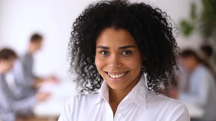 Wall Mural - Smiling african-american female employee worker intern posing in modern office